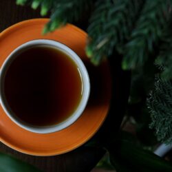 Cup of strong dark breakfast tea in an orange cup and saucer