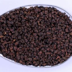 Small graded black tea particles heaped on a spoon