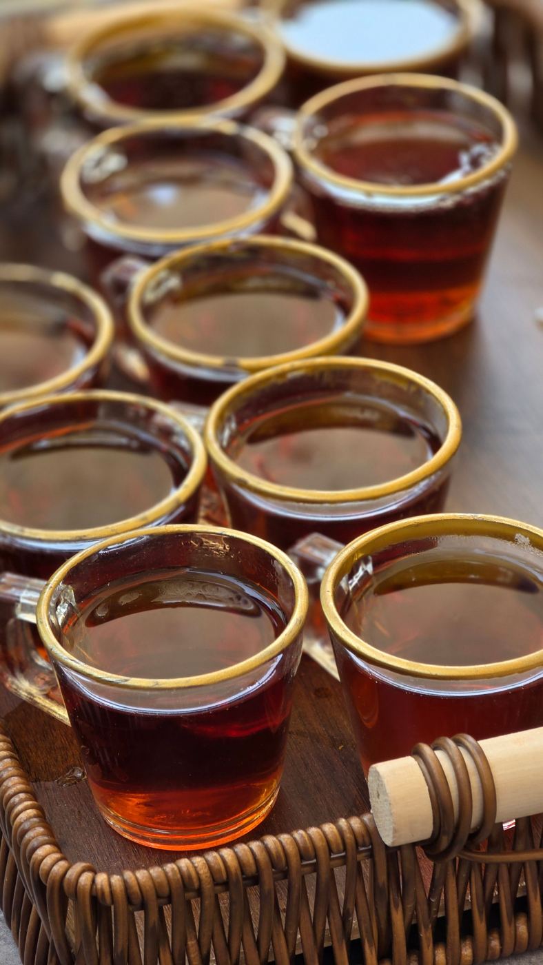 Uniform glass cups of brewed tea arranged in rows for side-by-side tasting evaluation