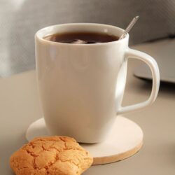 Mug of tea with a biscuit set beside it for elevenses