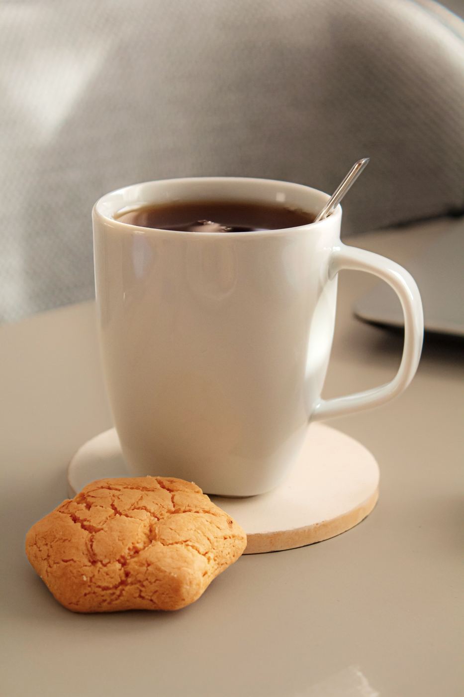 Mug of tea with a biscuit set beside it for elevenses