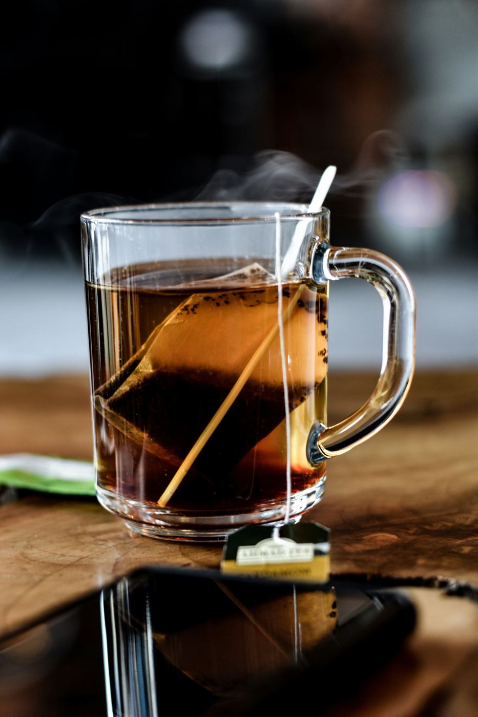 Glass mug of steaming English Breakfast black tea with tea bag steeping