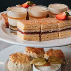 Two-tier stand with tea sandwiches, custard, and scones for high tea