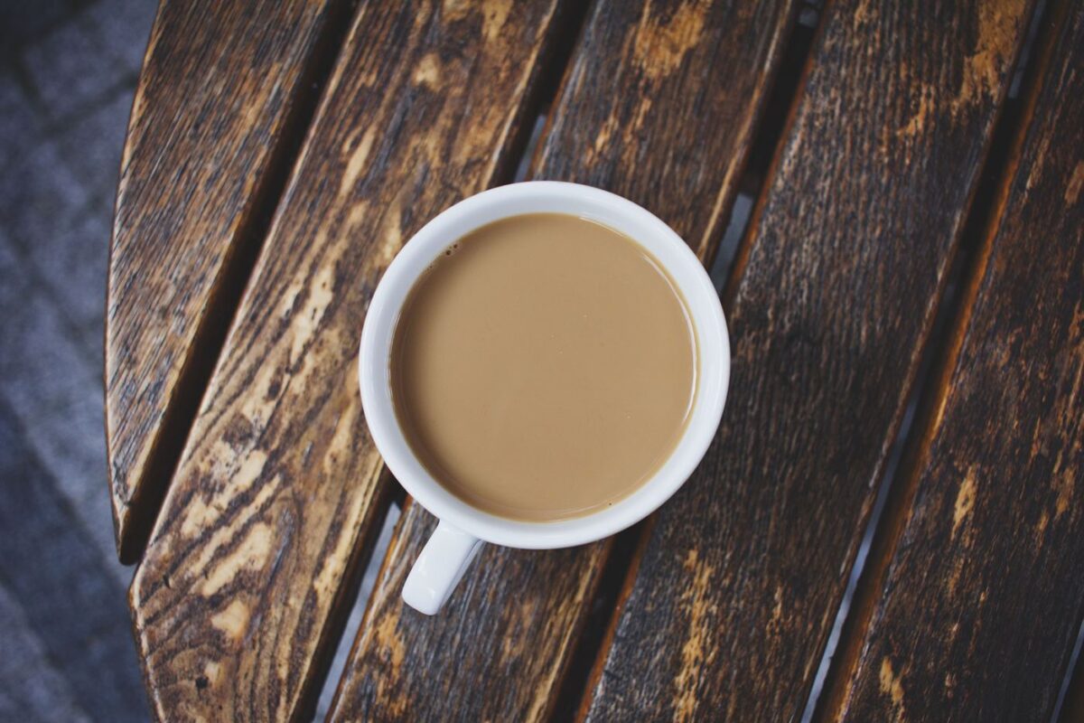 Cup of strong Irish Breakfast tea with milk on a rustic wooden table