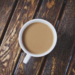 Cup of strong Irish Breakfast tea with milk on a rustic wooden table