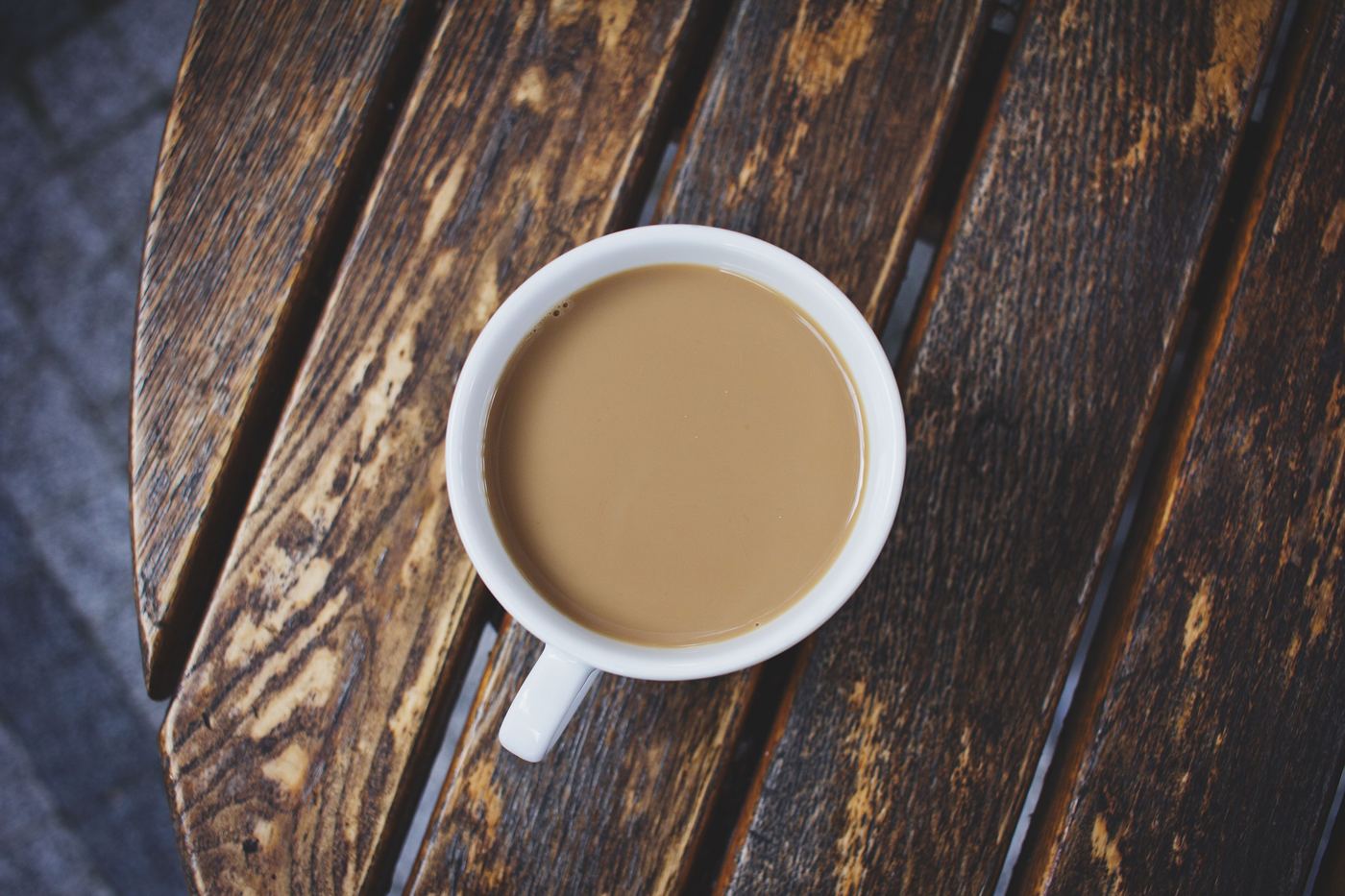 Cup of strong Irish Breakfast tea with milk on a rustic wooden table