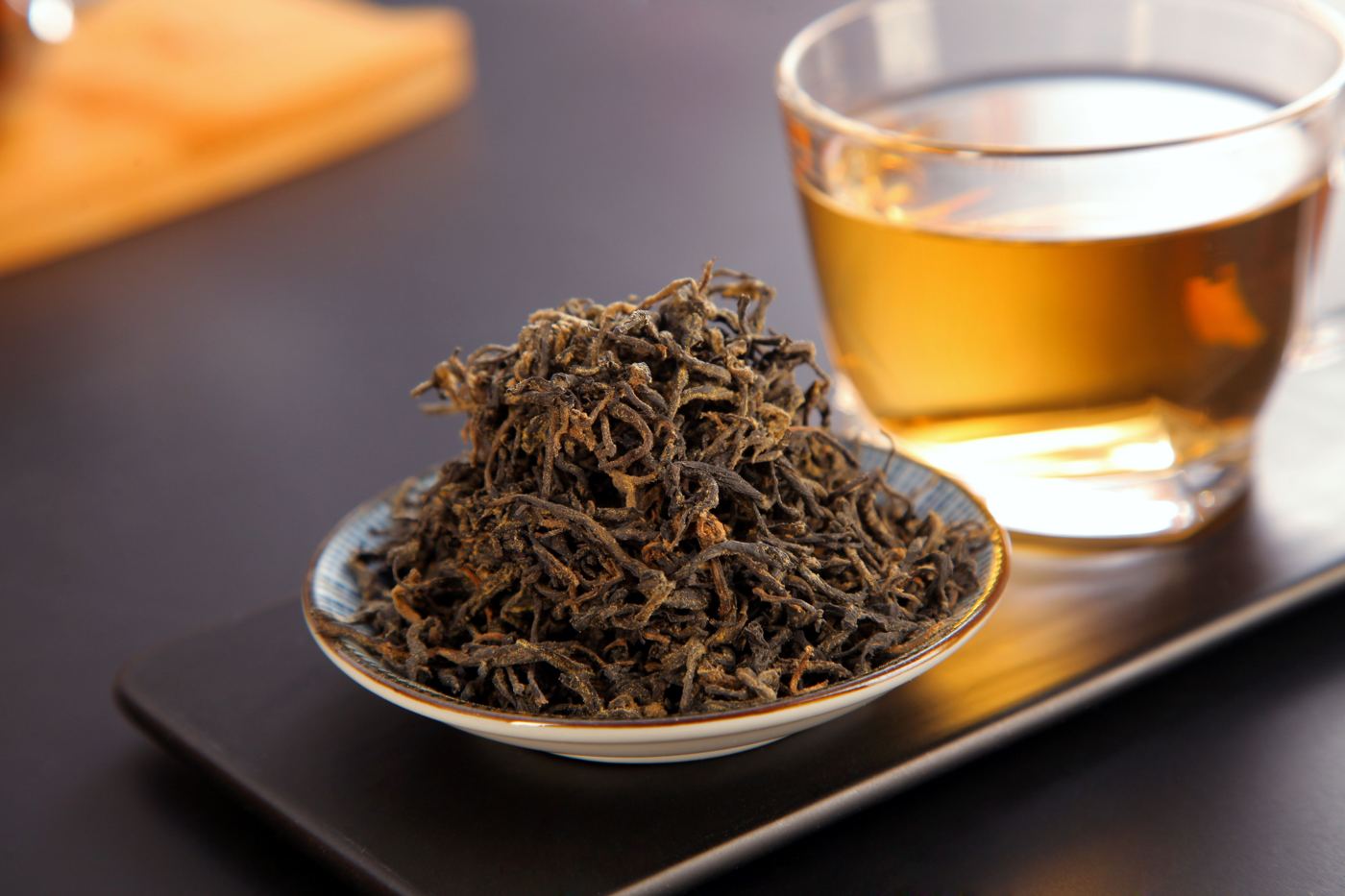 Loose leaf Keemun black tea beside a cup of brewed tea