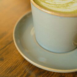 Matcha green tea latte with swirled latte art in a ceramic cup