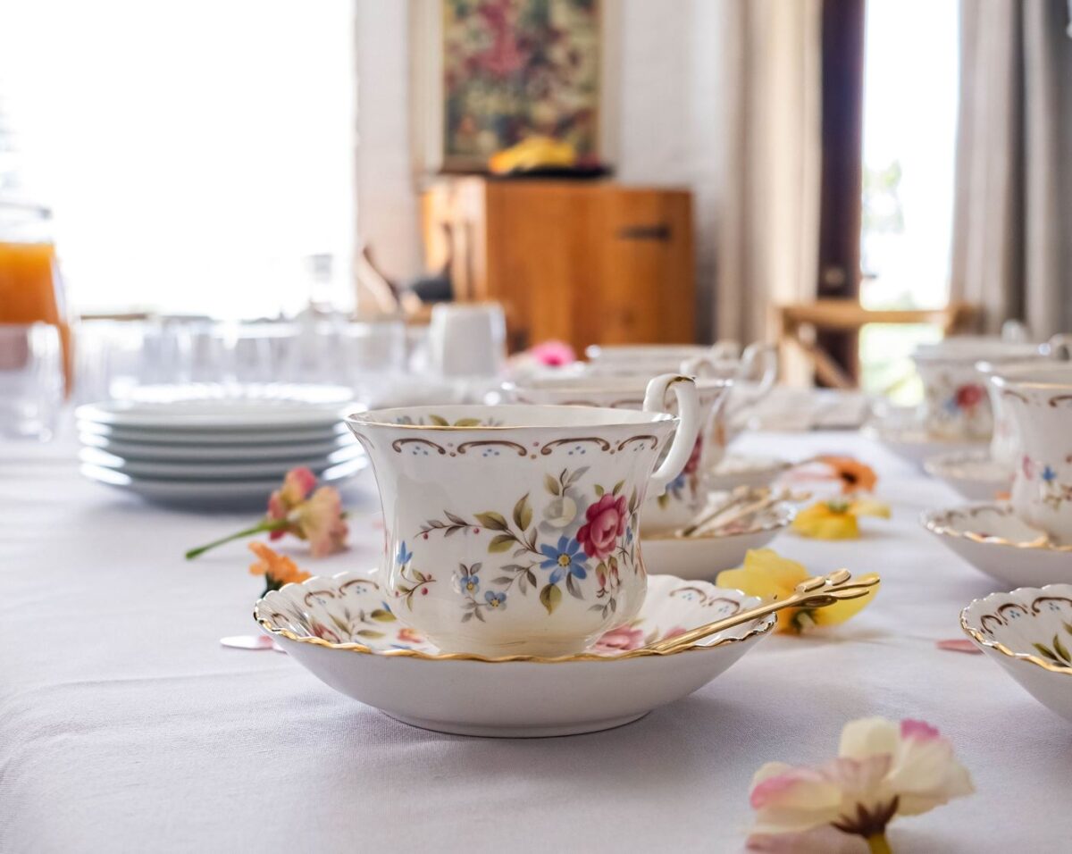 Ornate floral teacup and saucer on an elegantly set table