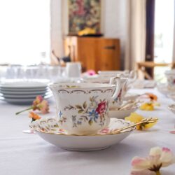 Ornate floral teacup and saucer on an elegantly set table