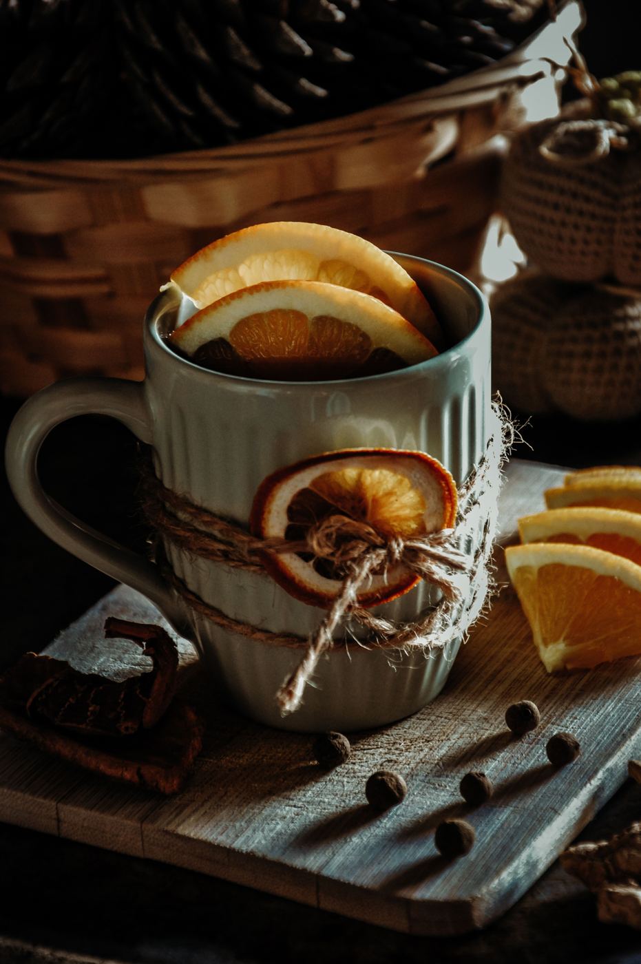 Mug of black tea garnished with dried orange slices, cinnamon sticks, and cloves