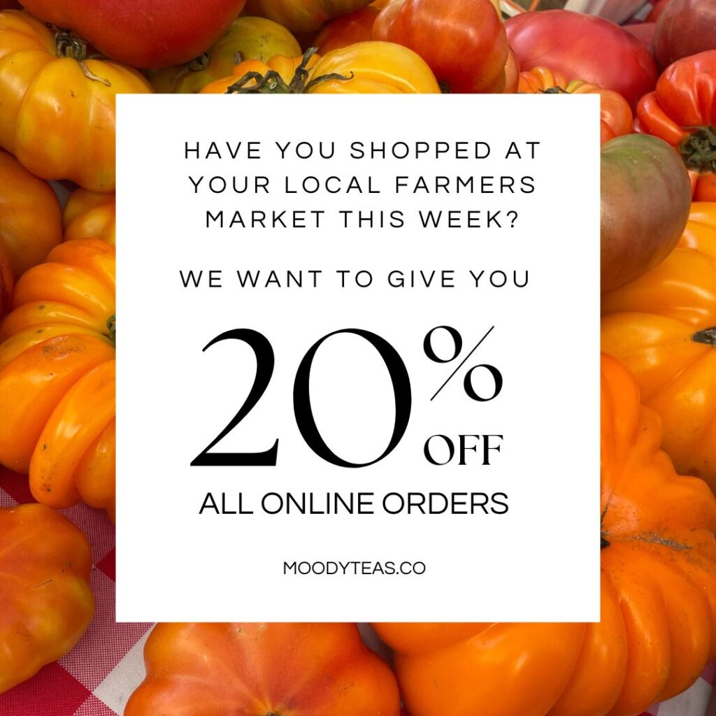 A vibrant display of yellow and red heirloom tomatoes at a farmers market. Overlaid text reads, "Have you shopped at your local farmers market this week? We want to give you 20% off all online orders." The Moody Teas website, "moodyteas.co," is listed at the bottom.