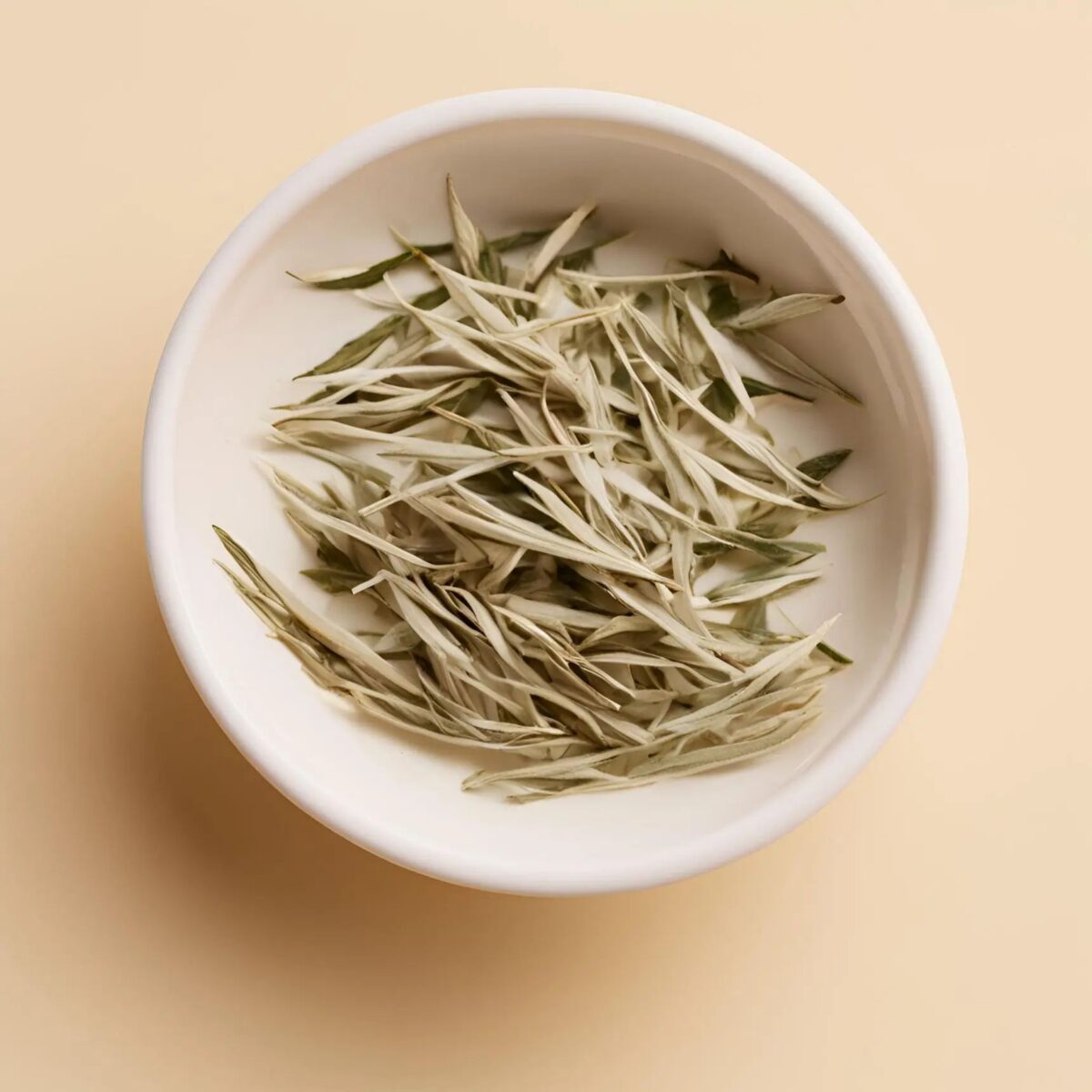 White tea leaves, silver-needle style, in a white bowl