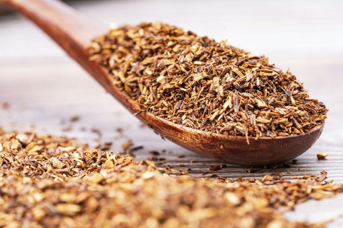 Cut red rooibos leaves on a wooden spoon