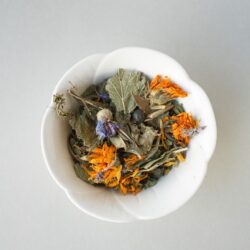 A bowl of dried marigold, cornflower, and leaves used for a tisane
