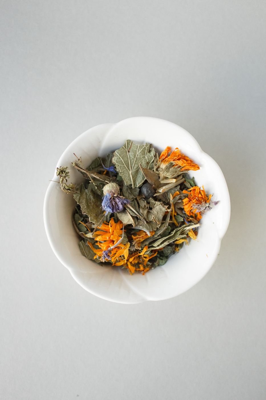 A bowl of dried marigold, cornflower, and leaves used for a tisane