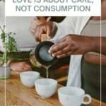 A person pours hot tea from a glass teapot into small white ceramic cups on a wooden table, with another person sitting nearby. The scene shows a shared tea moment in a warm, natural setting. Text over the image reads “Love is about care, not consumption,” with Moody Teas branding in the corner.